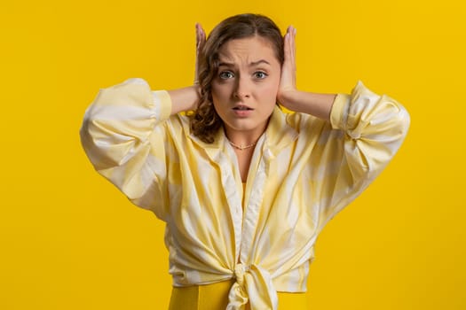 Dont want to hear and listen. Frustrated annoyed irritated woman covering ears gesturing No, avoiding advice ignoring unpleasant noise loud voices. Brunette girl isolated alone on yellow background