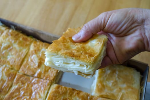 a tray full of pastries,turkish style cheese pie, water borek turkish style close-up, cheese pie,