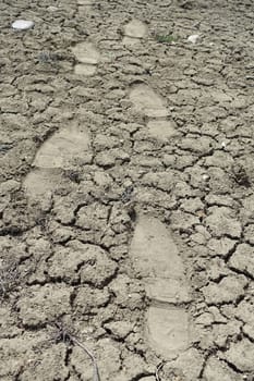 human footprints walking on cracked and cleft soils, human shoe prints in the soil,