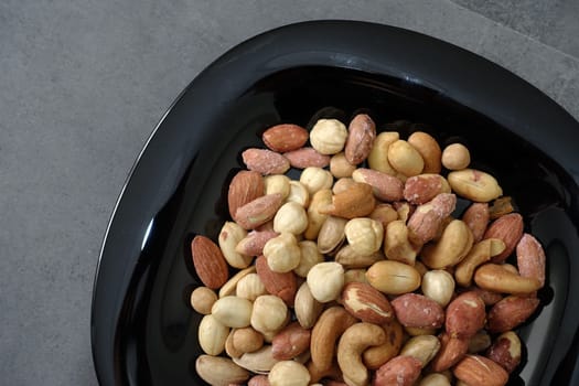 a bowl full of roasted hazelnuts, pistachios, cashews and a plate of various nuts,