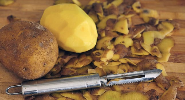 close-up peeling potatoes,person peeling potatoes to prepare a meal, close-up peeled potatoes and unpeeled potatoes,