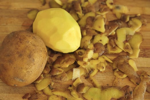 close-up peeling potatoes,person peeling potatoes to prepare a meal, close-up peeled potatoes and unpeeled potatoes,