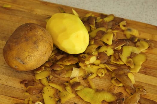 close-up peeling potatoes,person peeling potatoes to prepare a meal, close-up peeled potatoes and unpeeled potatoes,