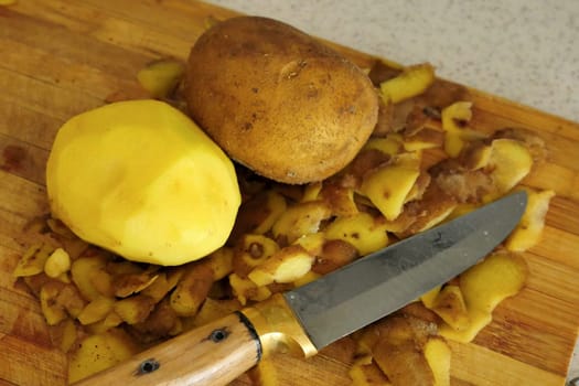 close-up peeling potatoes,person peeling potatoes to prepare a meal, close-up peeled potatoes and unpeeled potatoes,