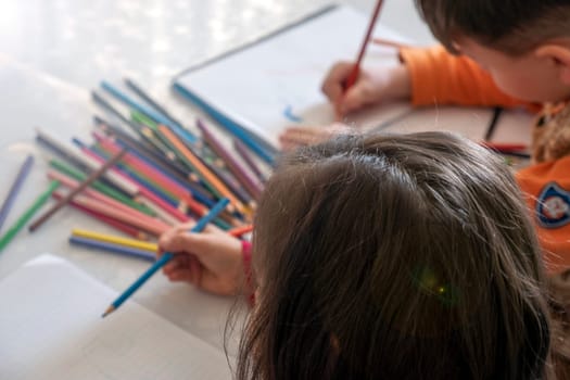 little girl coloring with crayons at the table,close-up of kindergarten kids coloring,