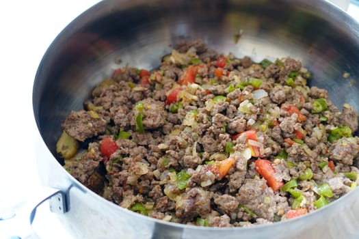 ground beef with tomatoes and onions in a pot,