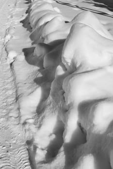 snow puddle on the roadside, transportation and snow barrier, black and white snow landscape photos,