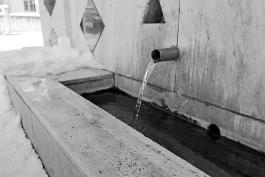 a fountain in the snow, a fountain that flows in winter,black and white fountain photo