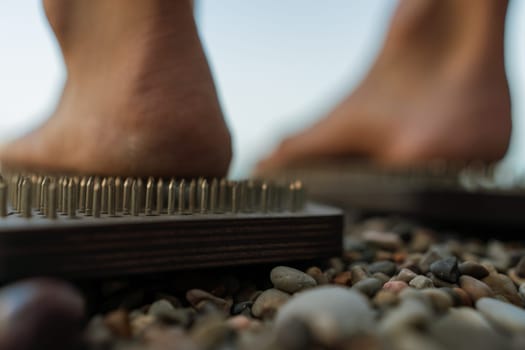 Sea Woman feet stepping on sadhu board during indian practice on the seashore. . Healthy lifestyle concept. tool for working out your inner state.