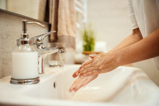 Closeup shot of an unrecognizable woman washing her hands with soap to prevent Coronavirus.