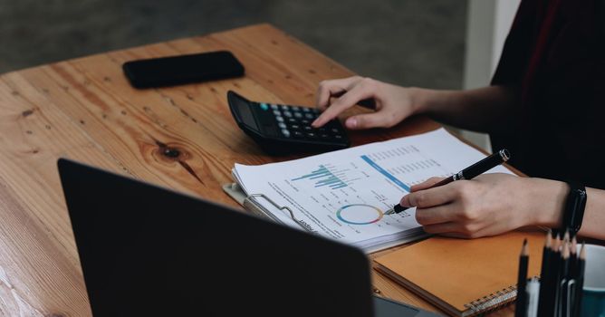 Business woman entrepreneur using a calculator to calculating financial expense at office. financial accounting concept.