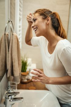 Shot of an attractive young woman wiping her face with a cotton pad in the bathroom at home.