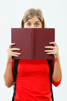 Portrait of female student hiding behind book.