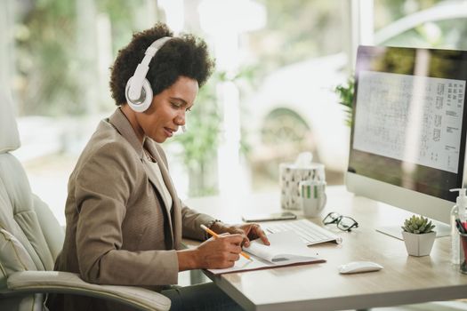 Shot of an African designer deep in thought while working on a computer in a modern office.