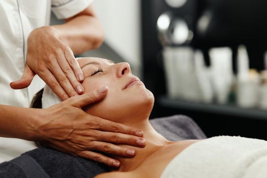Shot of a beautiful mature woman enjoying face massage at the beauty salon.