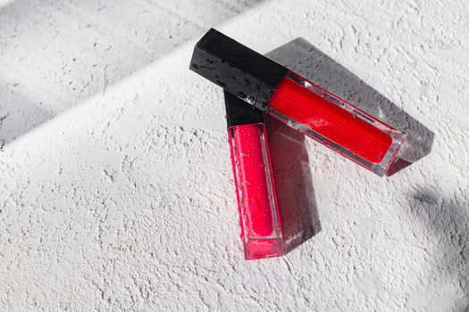 Lip gloss and sun shadow . The concept of lip gloss without labels. Decorative cosmetics. Lip care. Copy space