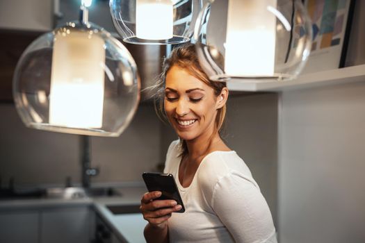 Attractive young woman using smartphone to surfing social media at home.