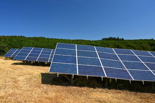 Solar power plant - concept for electricity and ecological industry. High energy prices. Beautiful landscape and sunny day with blue sky. Photovoltaic power plant.