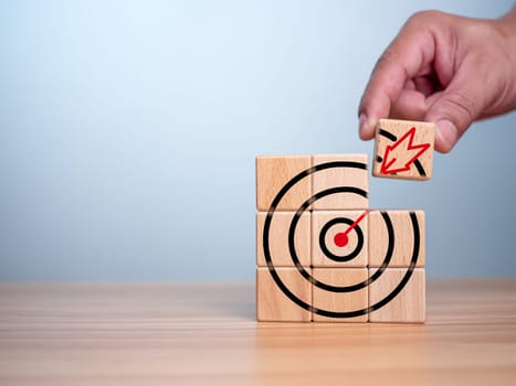 Businessman hands are completing wooden blocks with target sign. Startup concept. Business concept. Management concept. Business planning concept.