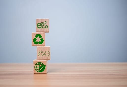 concept of waste reduction. Pollution. Reuse. Efficient use of resources. Environmental protection sign by recycling on wooden blocks placed on wooden table background.