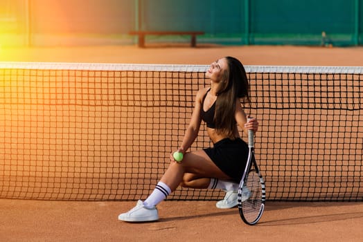Beautiful Woman On Tennis Court. Portrait Of Stylish Sexy Girl In Black Trendy Sportswear Holding Tennis Racket On Outdoor Court.