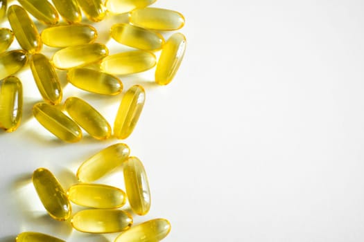 Oil filled capsules, softgel of food supplements. Fish oil, omega 3. Yellow softgels on white, copy space