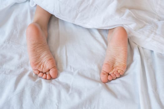 Close-up of a children legs on a white blanket.