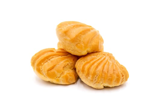 Group of three whole baked golden profiterole in line isolated on white background. Profiteroles with cream on a white background.