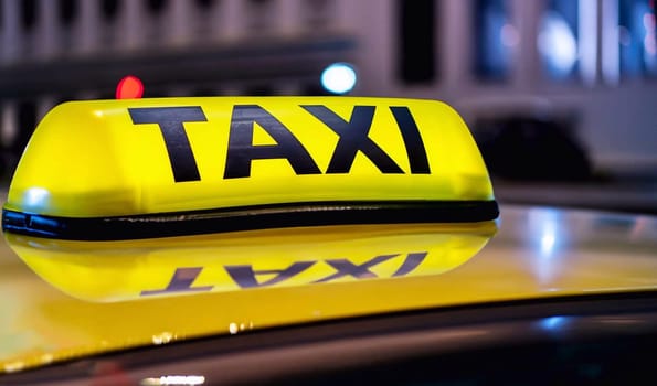Taxi,Munich. Yellow and black sign of a taxi put on a car at night