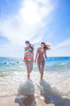 Happy smiling female friends in bikini on vacation