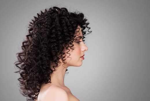 Profile portrait of young caucasian woman with curly hair