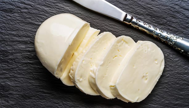 Sliced mozzarella on the grey cutting board