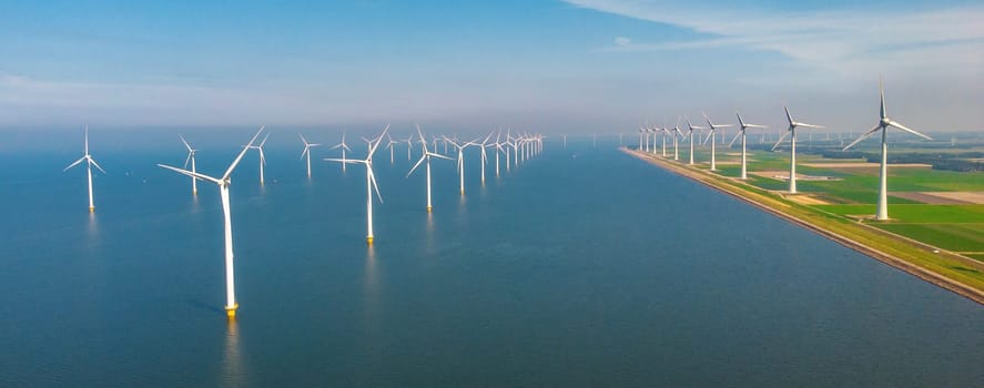 offshore windmill park with clouds and a blue sky, windmill park in the ocean aerial view with wind turbine Flevoland Netherlands Ijsselmeer. Green Energy in the Netherlands