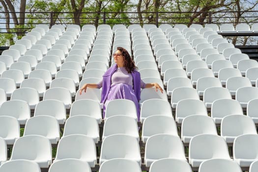 Woman Seats of tribune on sport stadium. Concept of fans, chairs for audience, cultural environment concept. mpty seats, modern stadium