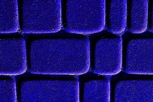 a wide way leading from one place to another, especially one with a specially prepared surface which vehicles can use. Neon blue brick road with shine.Cobblestones on the pavement close-up