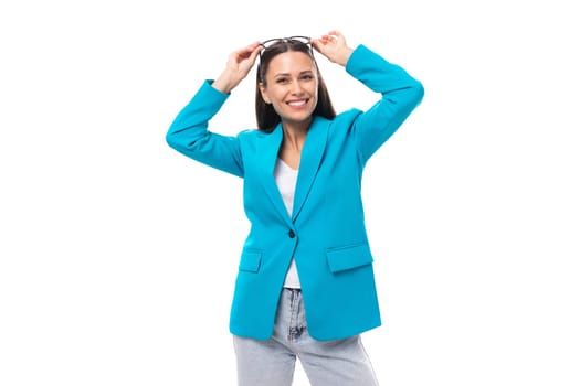 young pretty office worker woman in a blue business jacket looks successful and happy on a white background with copy space.