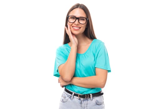 young attractive european woman with black long hair is wearing a blue t-shirt with glasses for vision.