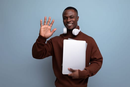 successful young african man businessman with laptop and headphones on background with copy space.