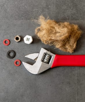 on the floor- there are wrench and plumbing linen- water seals- and water plug- close-up