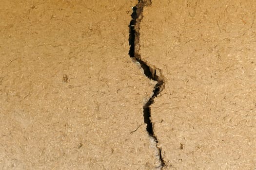 split and cracked adobe wall, wall slit, damaged adobe wall, village wall,