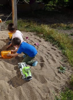 children playing in the sand, happy children playing in the sand in the garden,