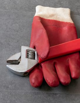 For work safety, it is necessary to work with gloves, a wrench, thick plastic gloves are standing on a floor,