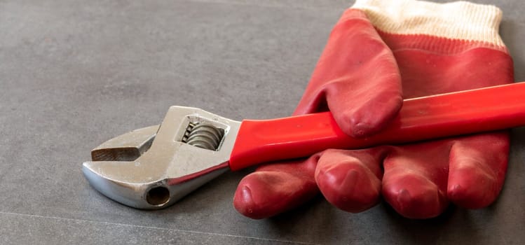 For work safety, it is necessary to work with gloves, a wrench, thick plastic gloves are standing on a floor,