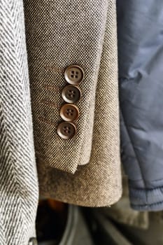 the cufflinks of the jacket hanging in the closet are visible,close-up coat-jacket,