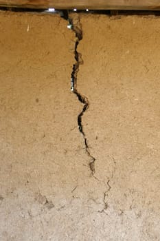 split and cracked adobe wall, wall slit, damaged adobe wall, village wall,