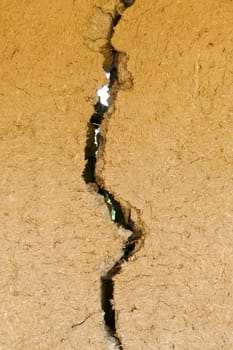 split and cracked adobe wall, wall slit, damaged adobe wall, village wall,