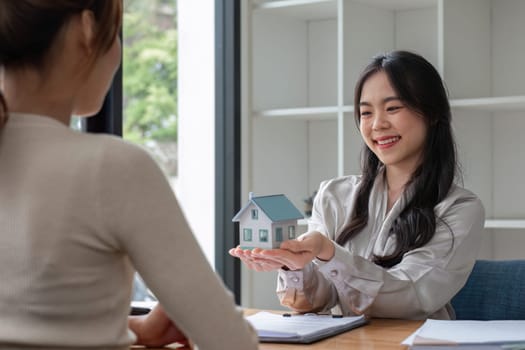 real estate agent or banker handing over a key to their customer after signing a contract.