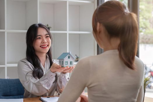 real estate agent or banker handing over a key to their customer after signing a contract.