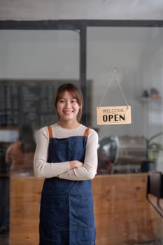 Successful small business owner. Beautiful girl with apron holding tablet standing in coffee shop restaurant. Portrait of asian woman barista cafe owner..