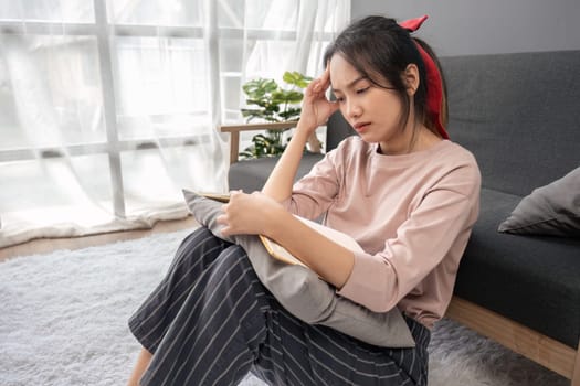 Female student reading a book for the exam or doing homework. young asian college student at hard exam..